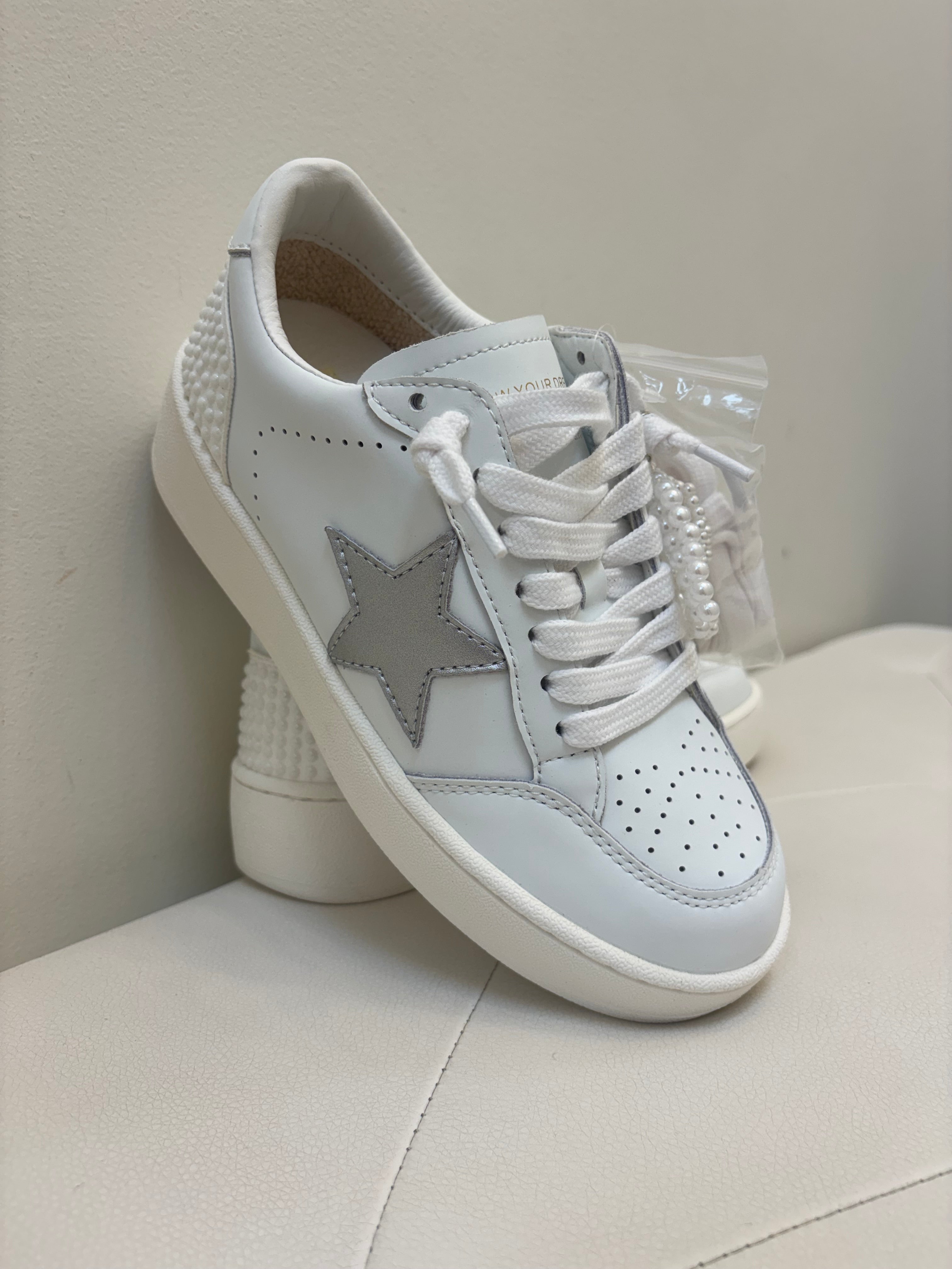 White sneakers with a gray star on a light background