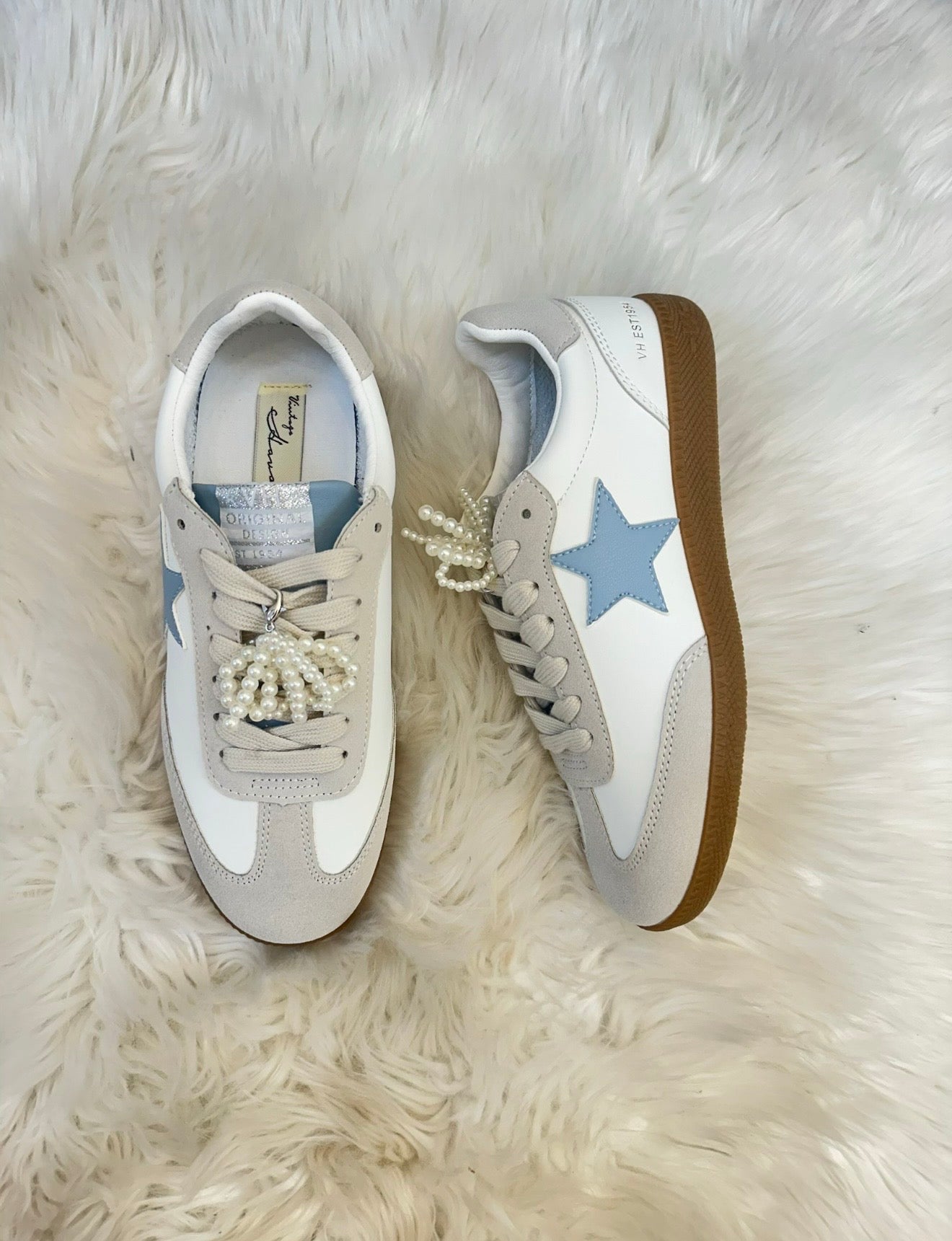 White sneakers with blue star and brown sole on a fluffy white surface