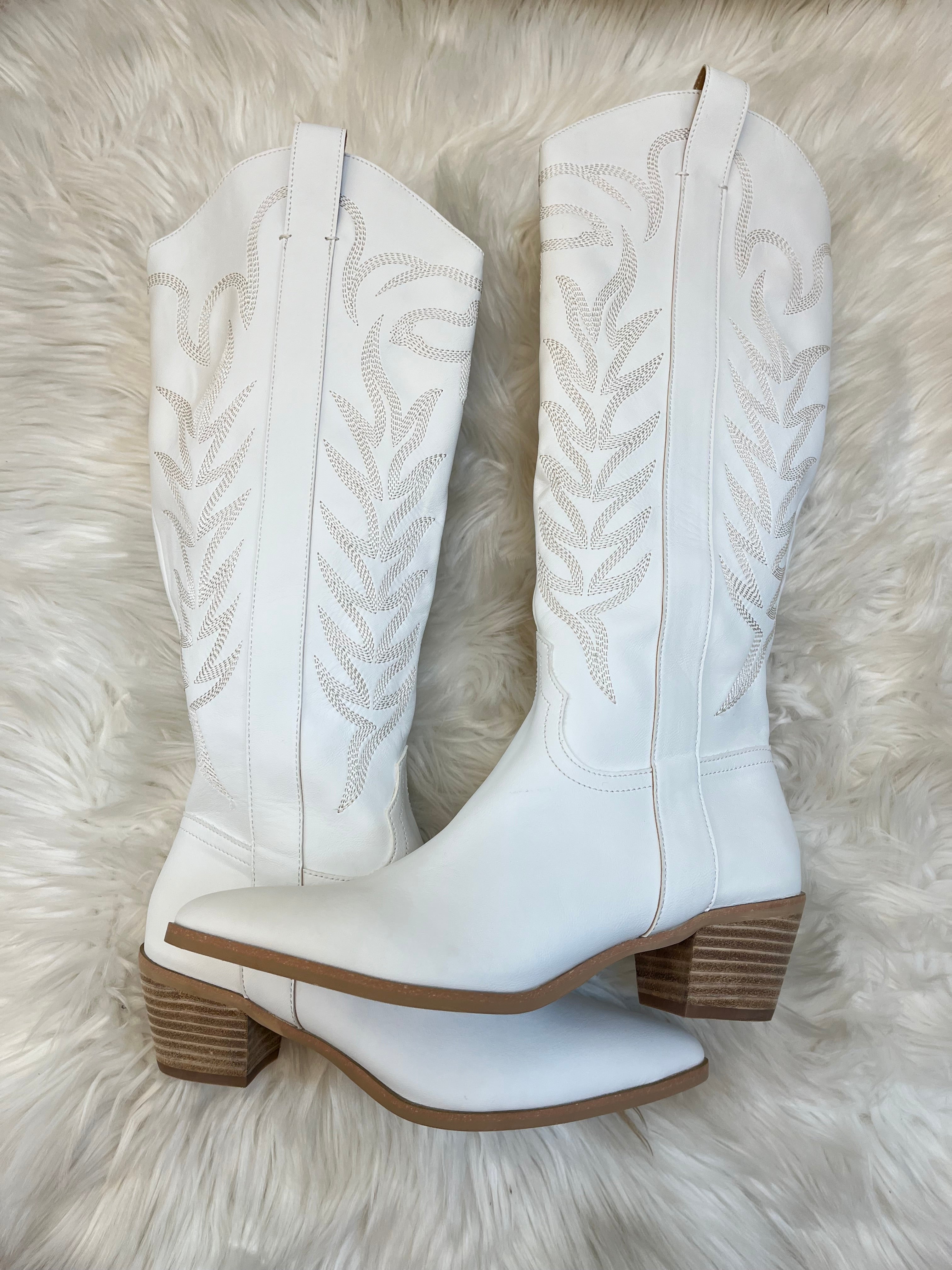 White ankle boots with brown soles on a fluffy white surface