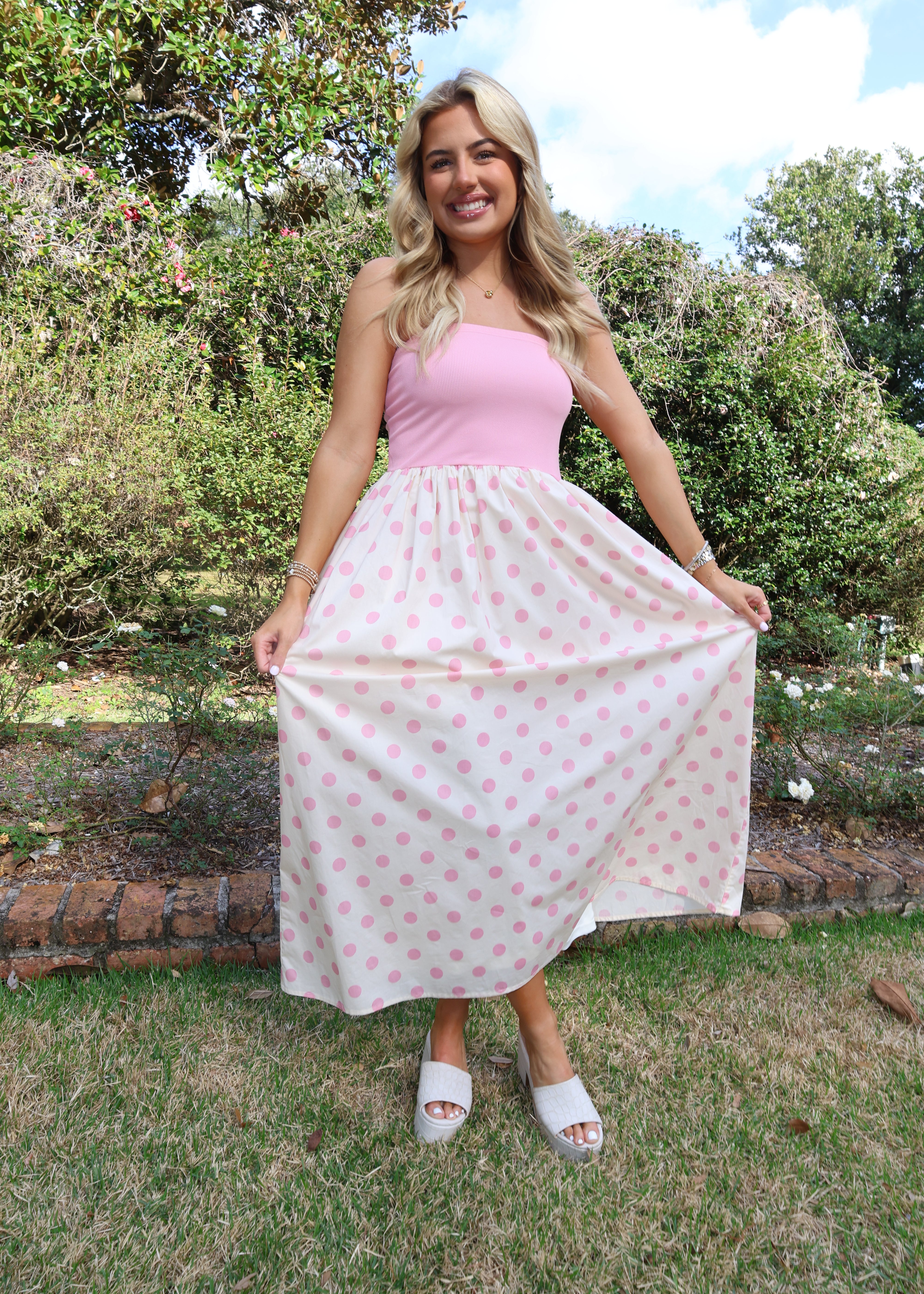 Woman holding a pink polka dot blanket outdoors