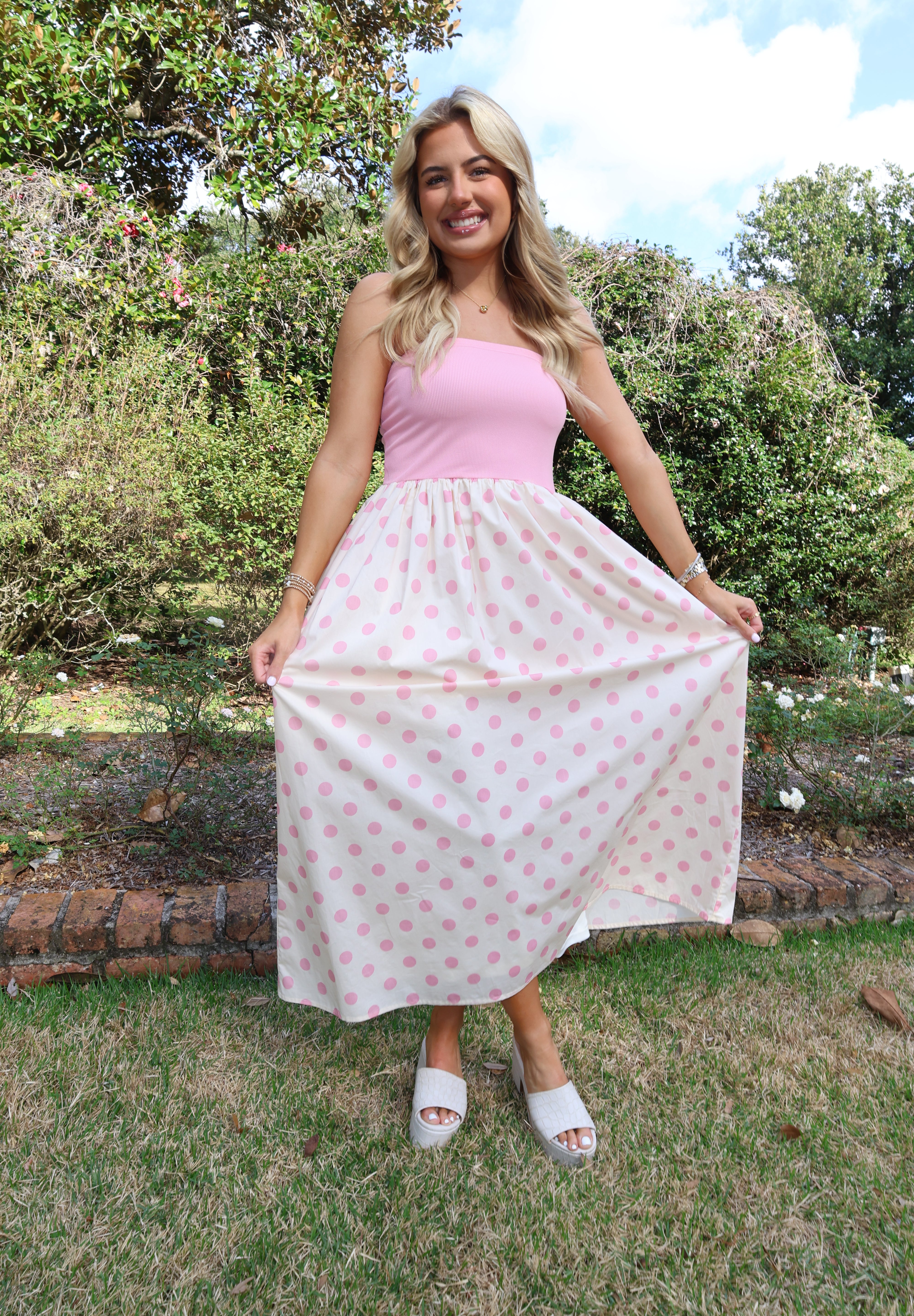 Woman holding a pink polka dot blanket outdoors
