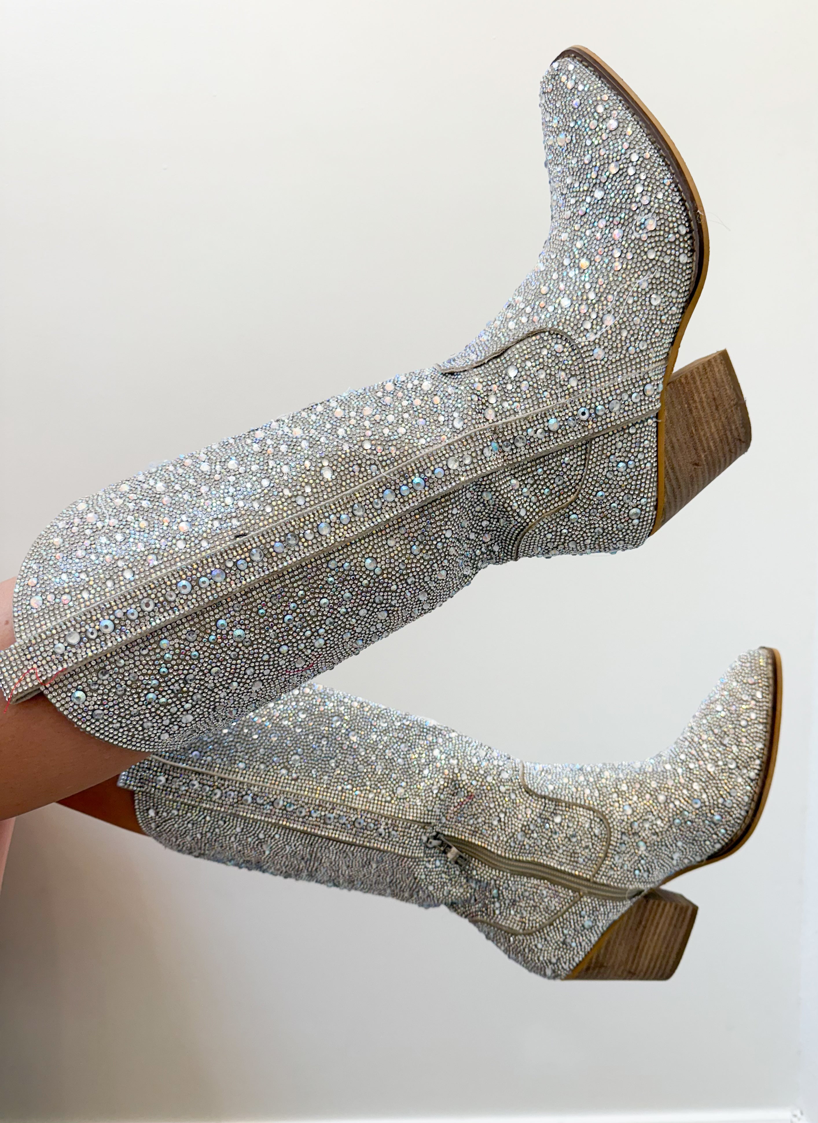 Silver glittery boots with brown soles on a white background