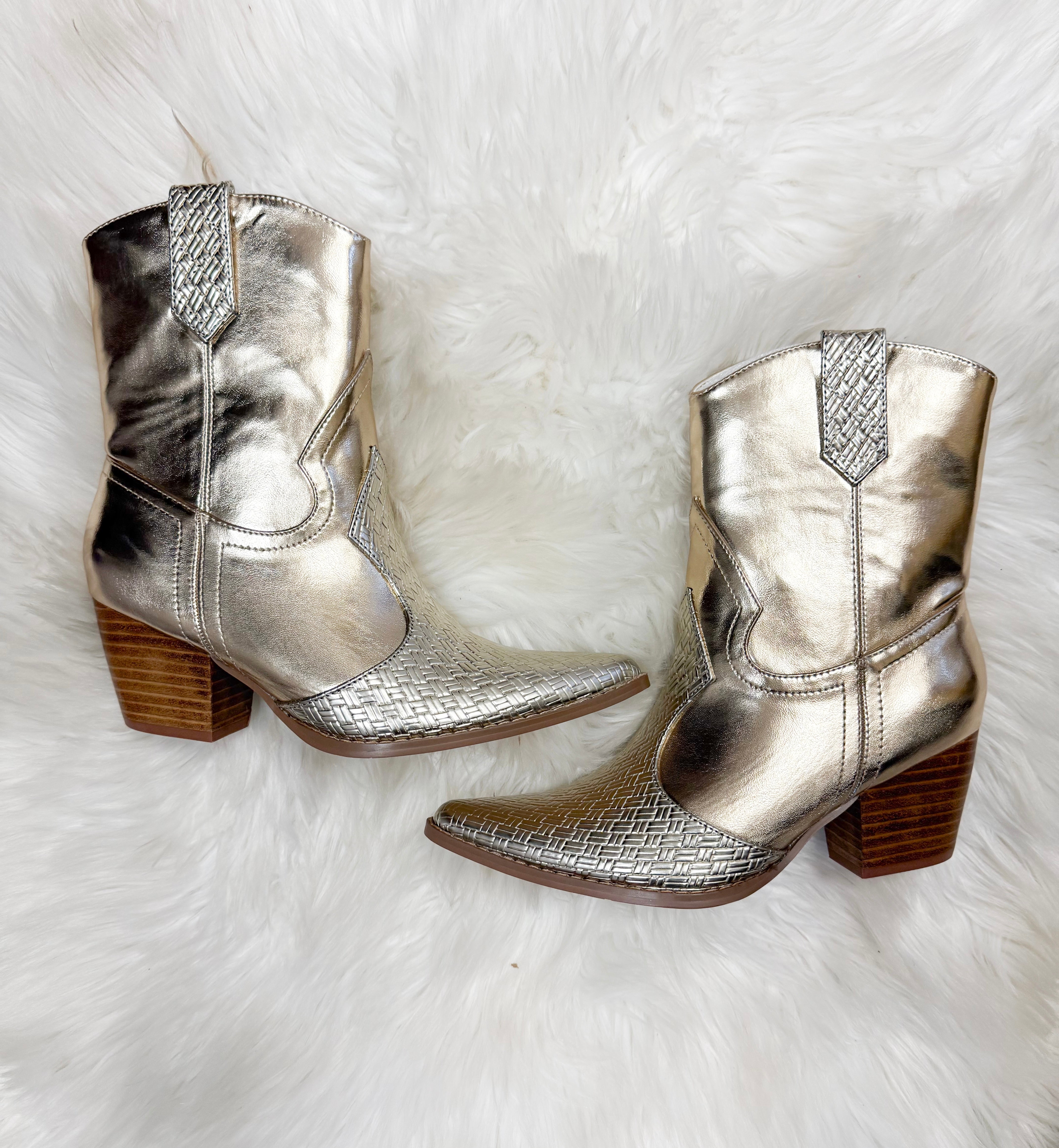 Pair of metallic silver cowboy boots on a white fur background